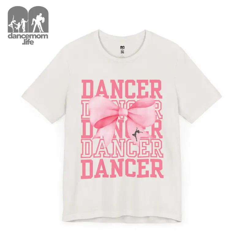 White t-shirt with pink ’DANCER’ text and bow design printed on the front.