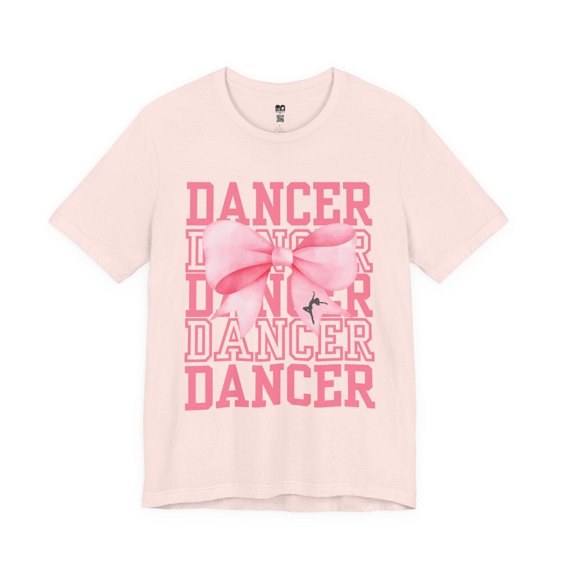 A soft blush pink cotton t-shirt featuring a bold graphic of the word ’dancer’ repeated in stacked rows with a large, stylized pink bow centered over it.