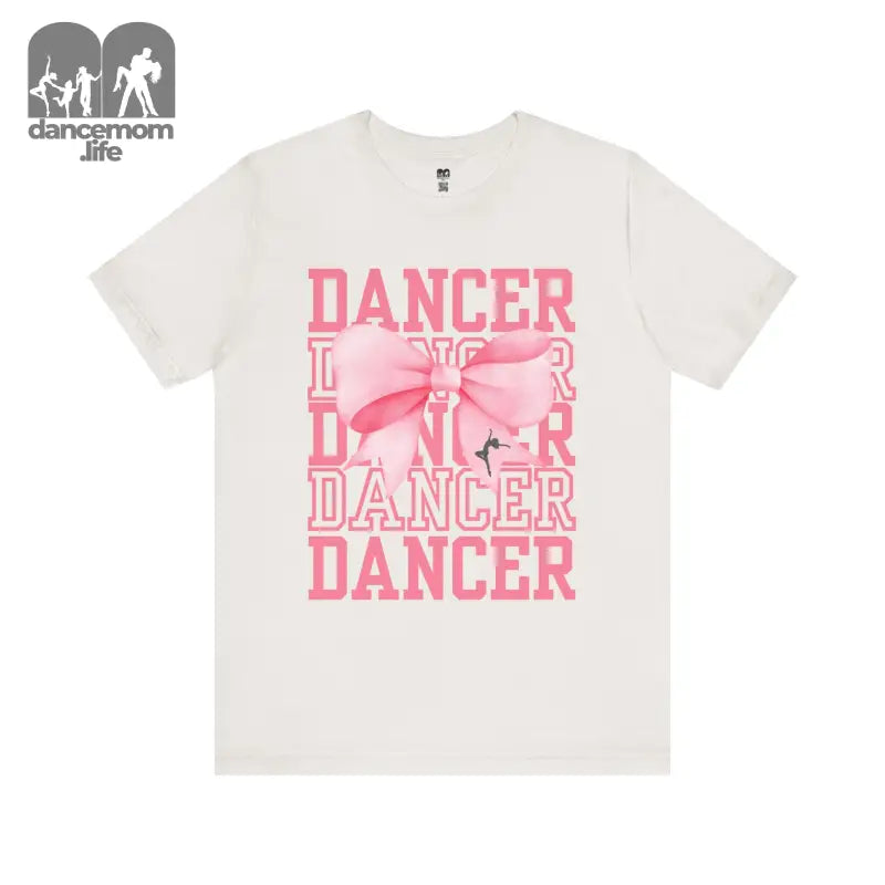 White t-shirt with pink ’DANCER’ text and bow design printed on the front.