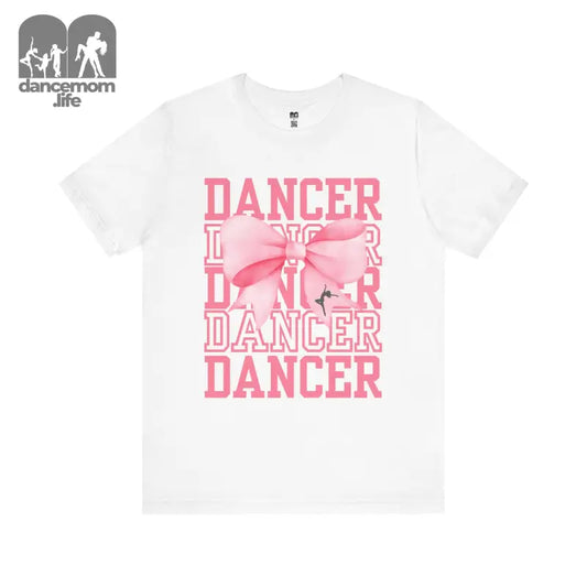 White t-shirt with pink ’DANCER’ text and bow design.