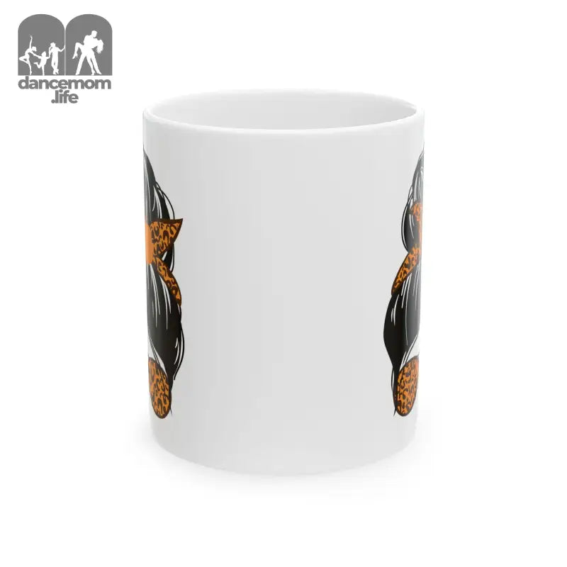 White ceramic mug with black and orange cat designs on its surface.