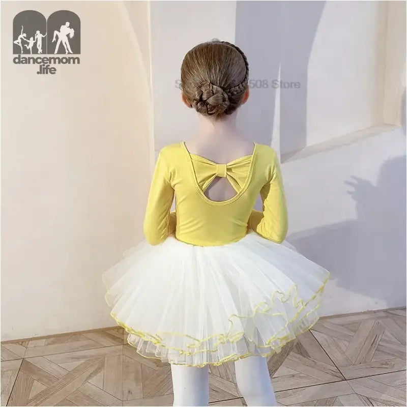 Yellow leotard with white tutu and bow back detail worn by a ballet dancer.