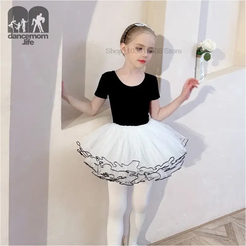 Classic ballet outfit featuring a black leotard and white tutu with decorative black trim.