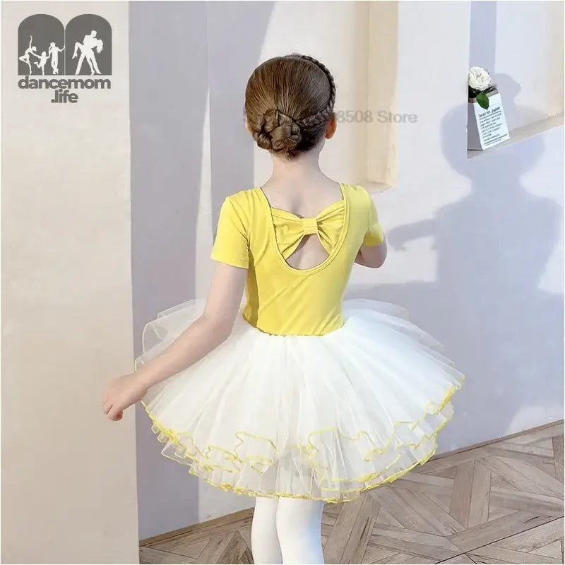 Yellow and white ballet dress with a bow detail and tutu skirt.