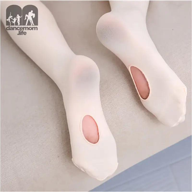 White ballet tights with holes worn at the heels.