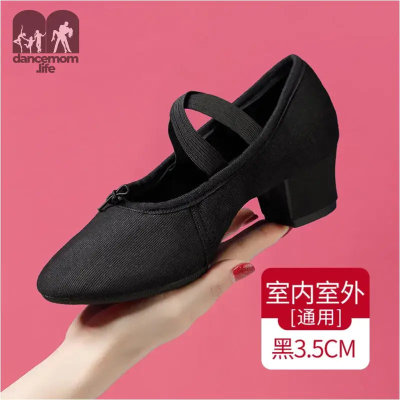 Black canvas dance shoe with criss-cross strap.