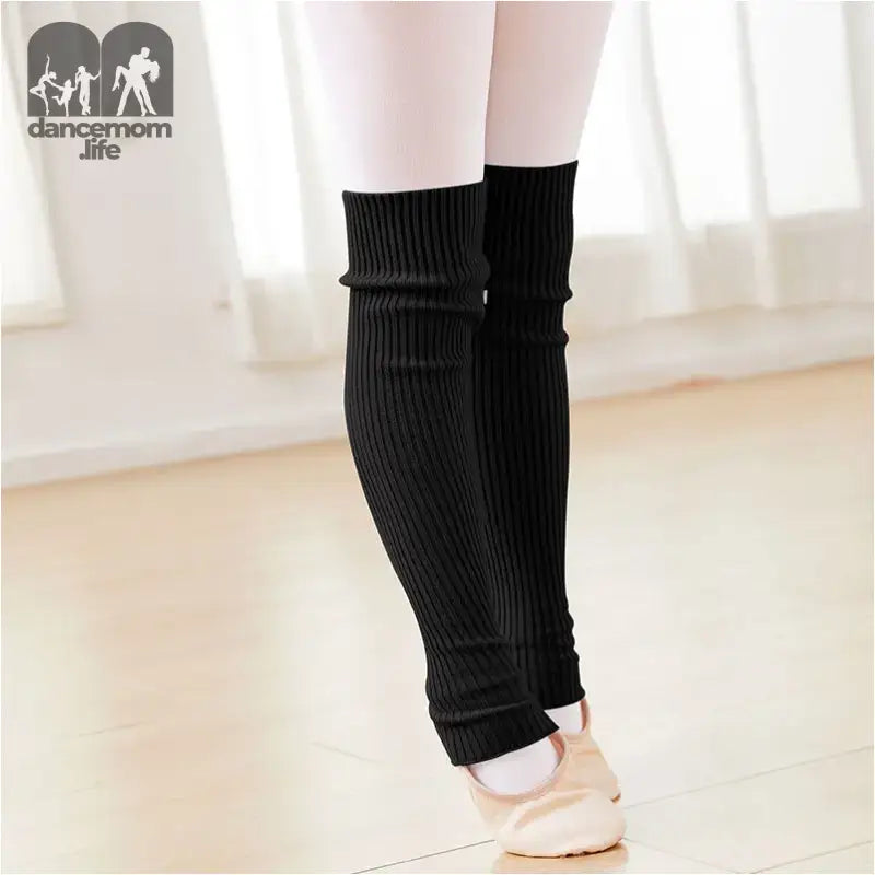 Black knitted leg warmers worn over ballet shoes.