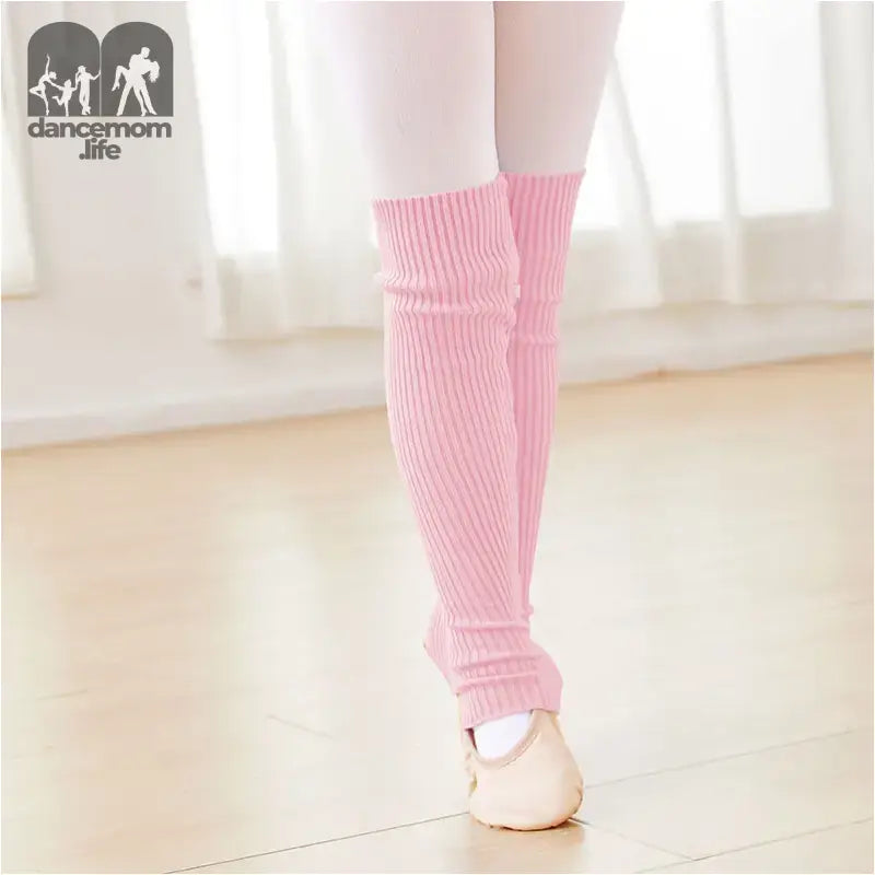 Pink knit leg warmers worn over ballet shoes.