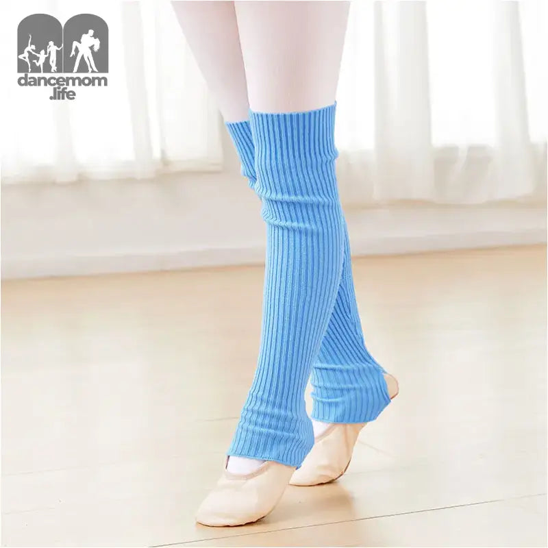 Light blue knitted leg warmers worn over ballet shoes.