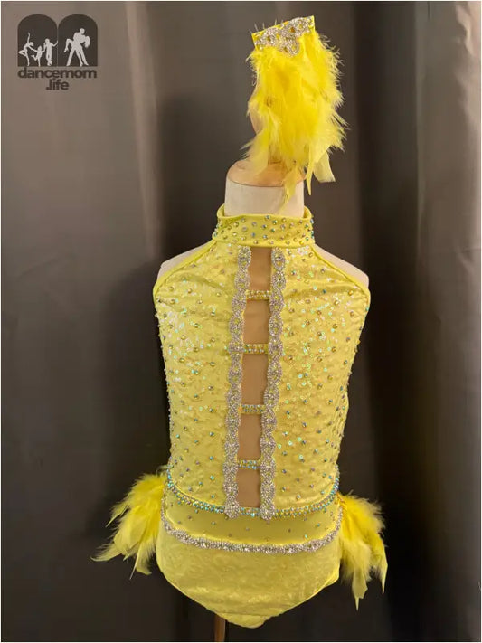 Yellow sequined dance costume with feather accents and rhinestone trim.