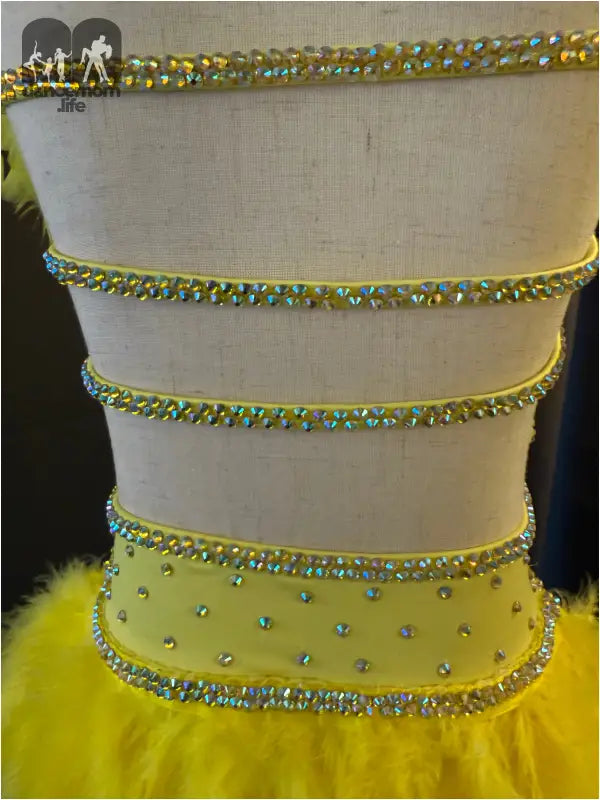 Yellow dress bodice with crystal rhinestone trim and cutout details.