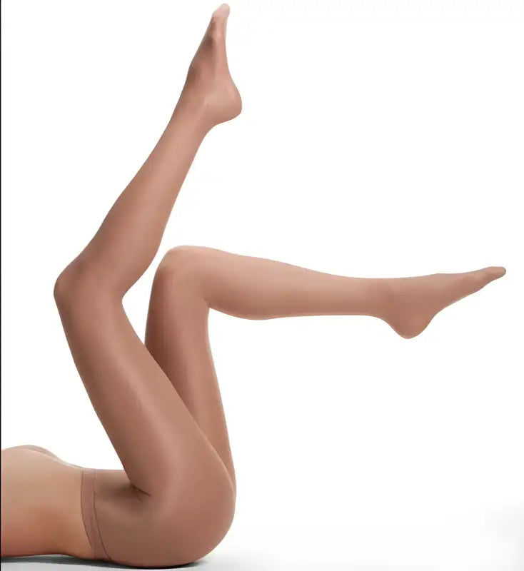 Pair of legs wearing sheer nude pantyhose in a raised pose.