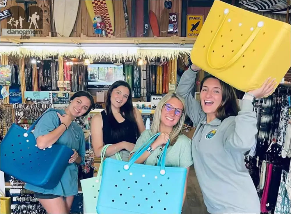Four women holding colorful tote bags.