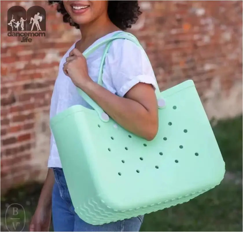 Mint green tote bag with holes.