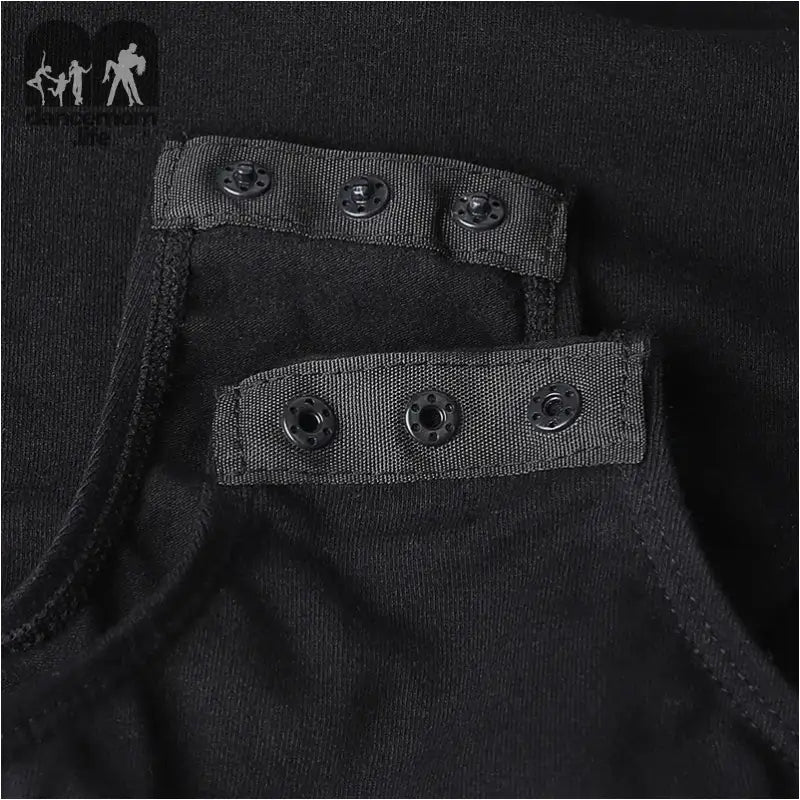 Black fabric garment with snap button closures.