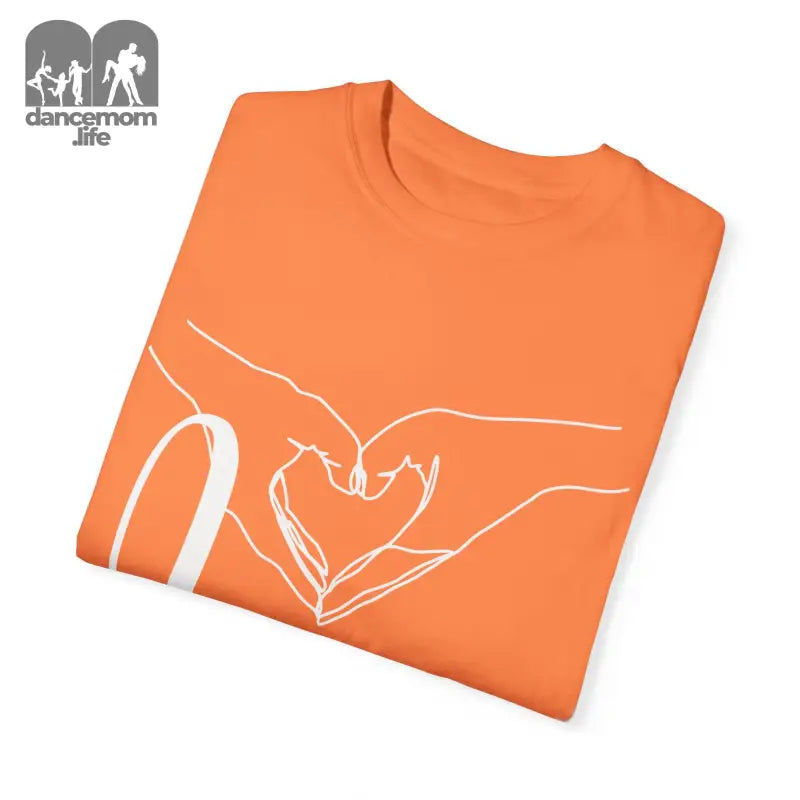 Orange t-shirt with white hand-drawn heart design formed by two hands.