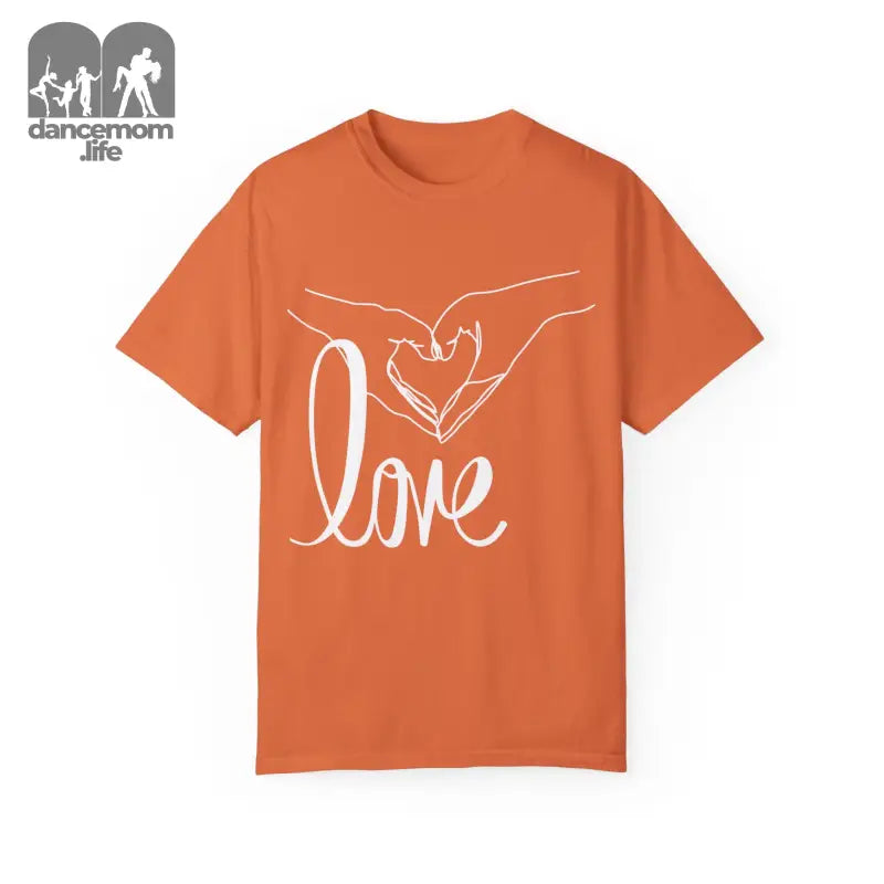 Orange t-shirt with white hands forming a heart shape and the word ’love’ printed on it.