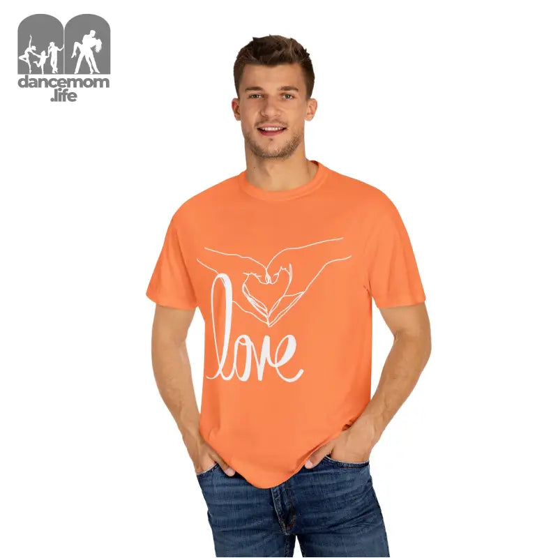 Orange t-shirt with a white ’love’ design featuring hands forming a heart shape.