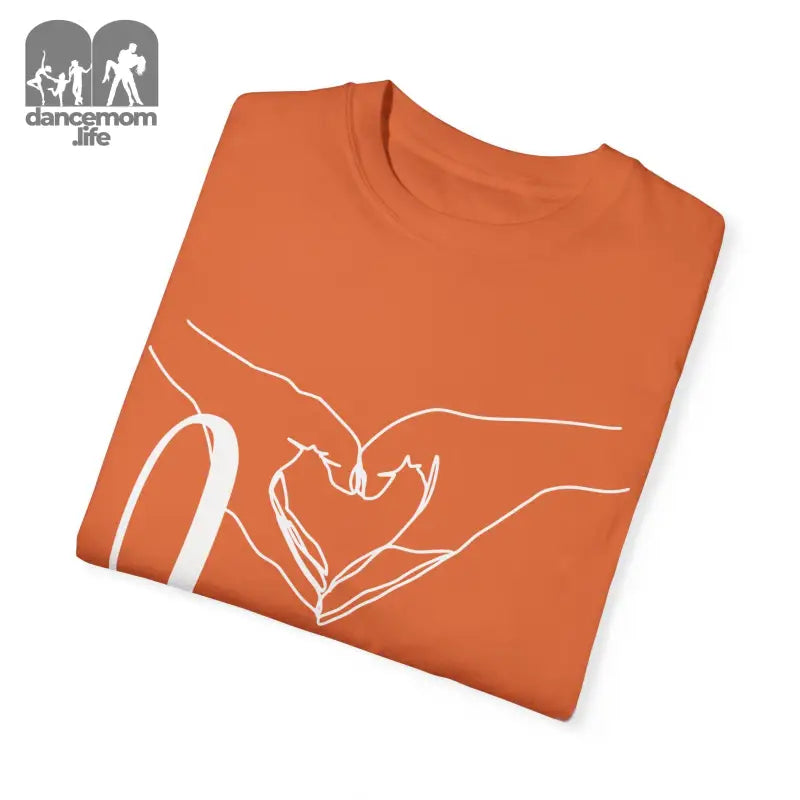 Orange t-shirt with white line art showing hands forming a heart shape.