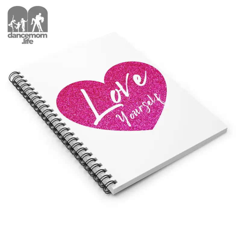 Spiral-bound notebook with a pink glittery heart and ’Love yourself’ text on the cover.