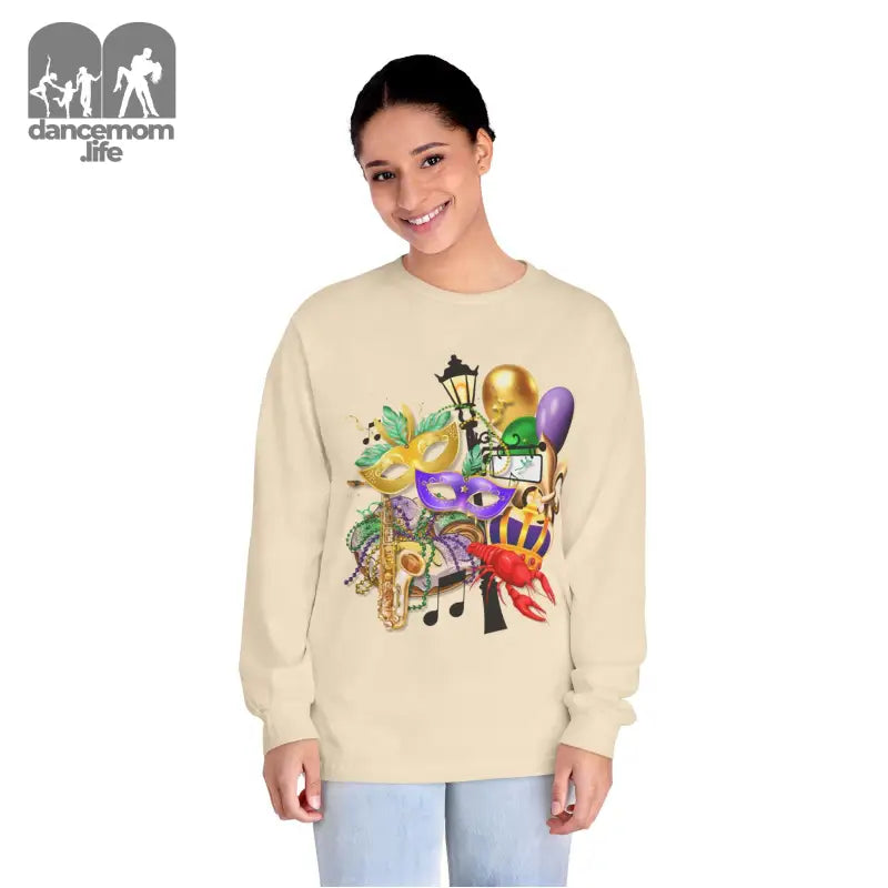 Beige sweatshirt featuring colorful Mardi Gras themed artwork with masks, musical notes, and festive decorations.