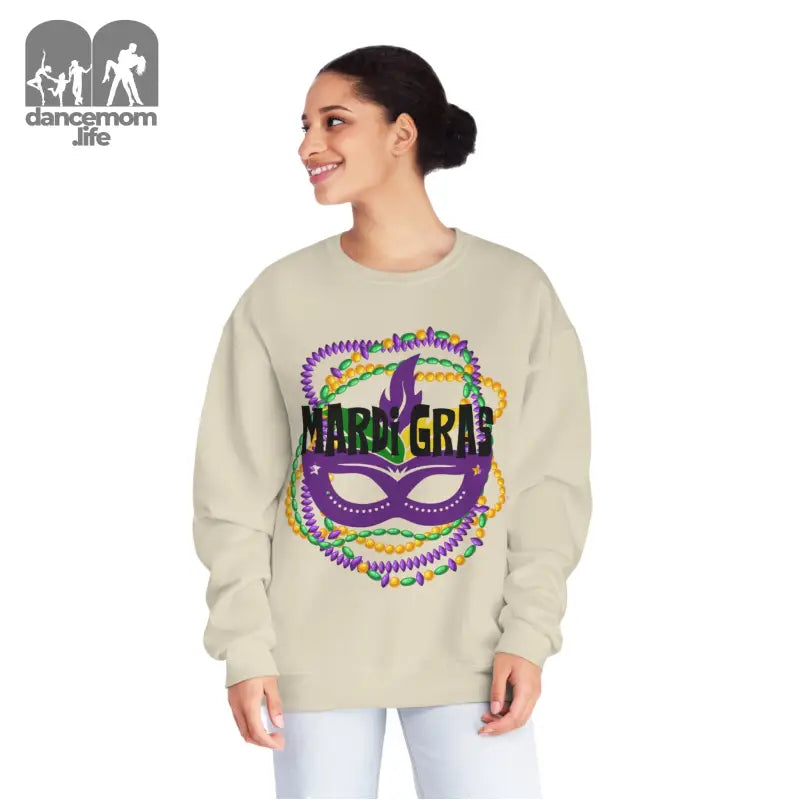 Beige sweatshirt featuring a colorful Mardi Gras mask design with purple, green and gold accents.