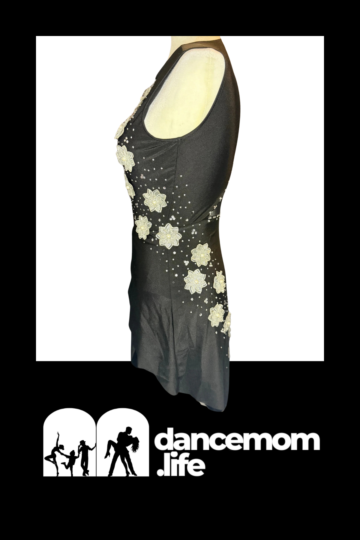 Black sleeveless dance dress adorned with intricate white floral appliqués and sparkling rhinestones.