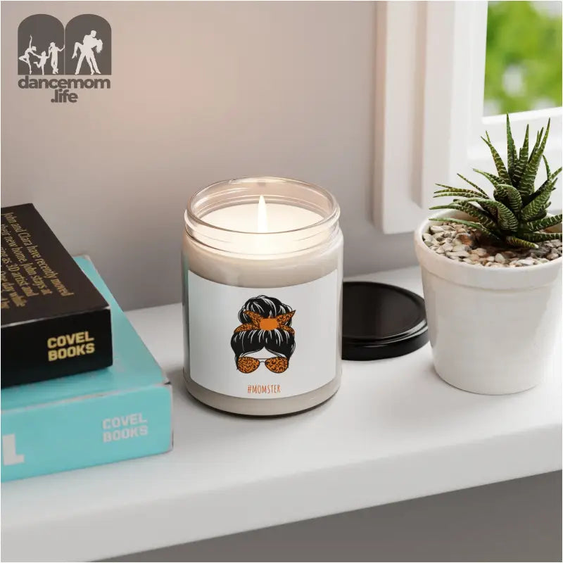 Glass jar candle with a cartoon messy bun and sunglasses design on its label.