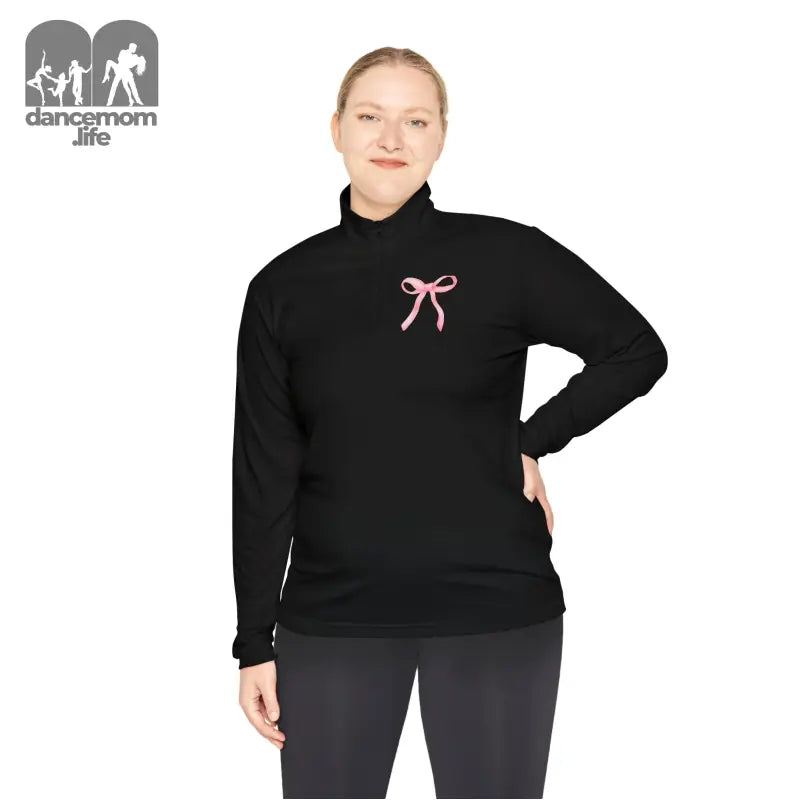 Black turtleneck sweater with a pink bow embellishment on the chest.