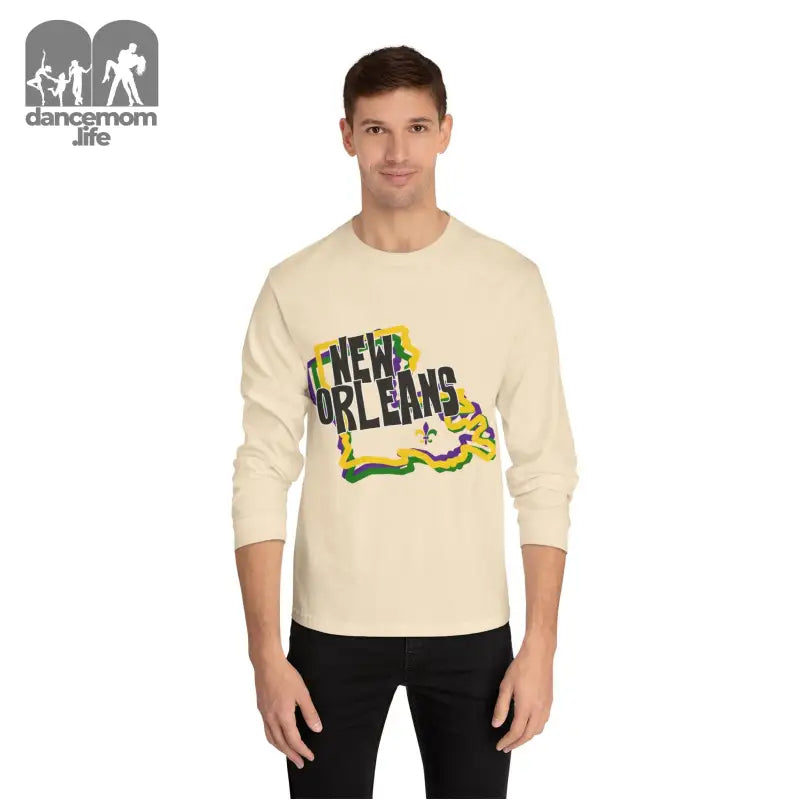 Cream-colored long sleeve t-shirt with ’New Orleans’ text design featuring Mardi Gras colors and decorative elements.