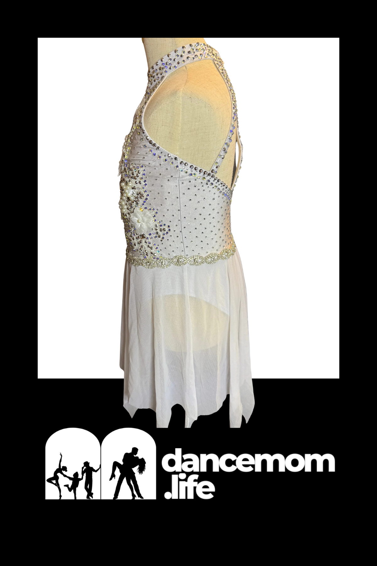 A white, embellished dance dress with a beaded bodice and sheer skirt.