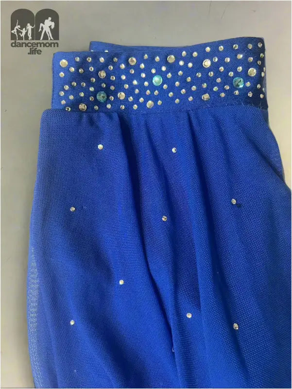 Blue fabric garment with silver studded embellishments along the waistband and scattered across the body.