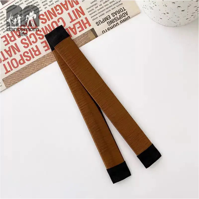 Brown hair styling tool with black ends.