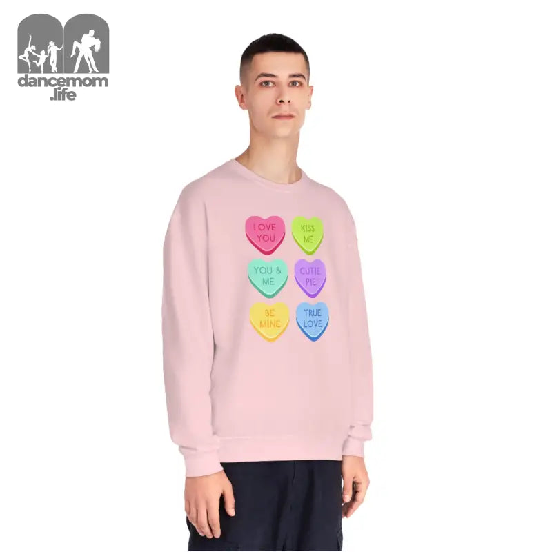 Pink sweatshirt featuring colorful candy heart designs arranged in a grid pattern.