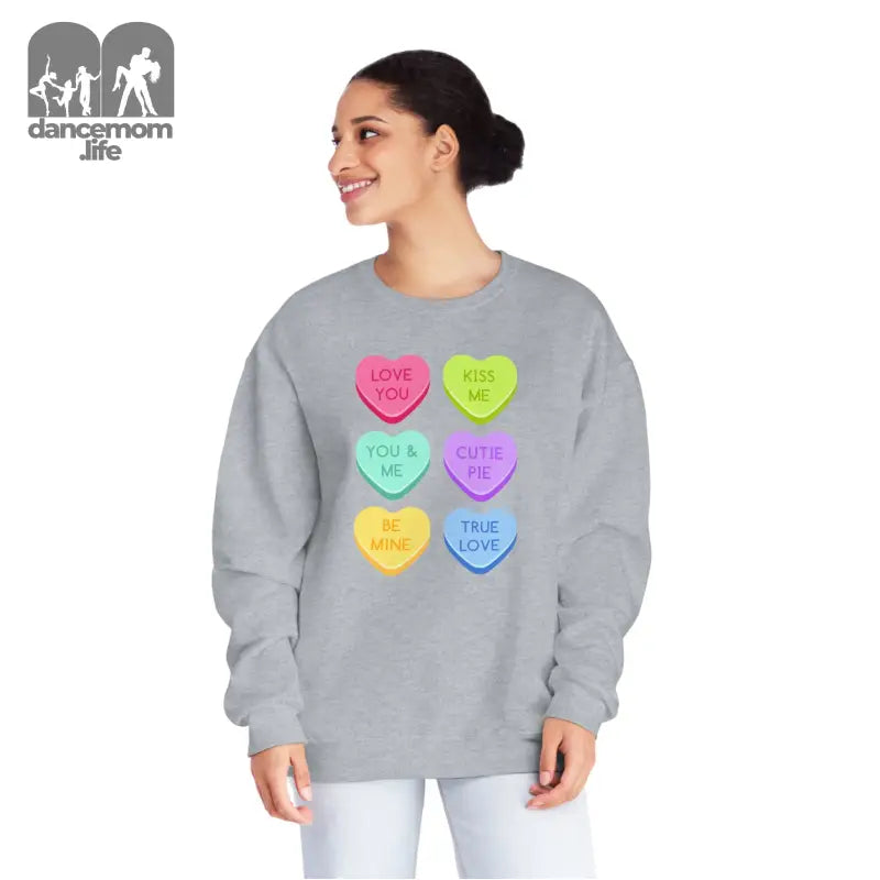 Grey sweatshirt featuring colorful candy heart designs with text messages printed on them.