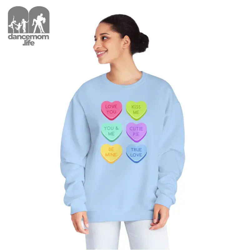 Light blue sweatshirt featuring colorful candy heart designs with text.