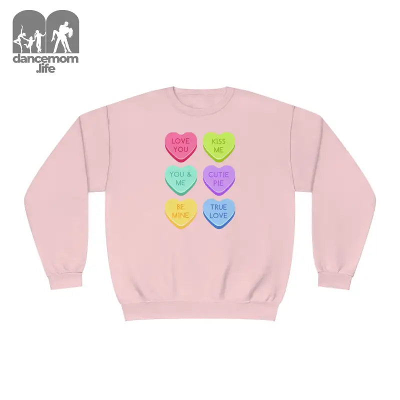 Pink sweatshirt with colorful candy heart designs printed on the front.